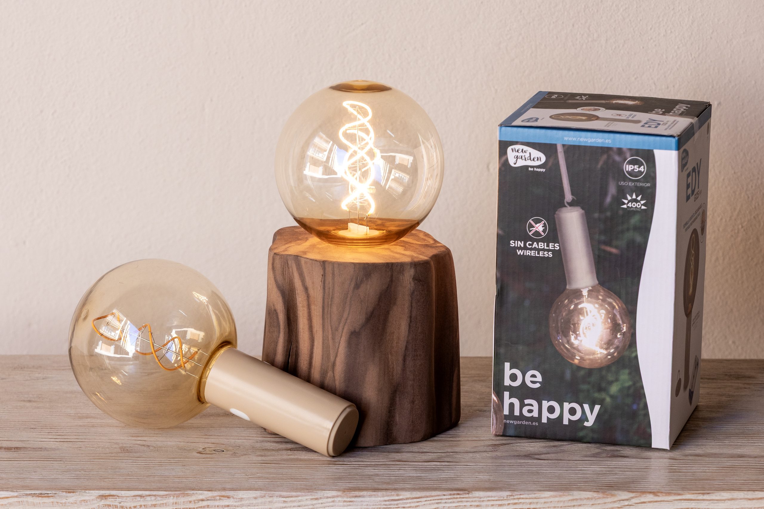 detall bombeta inalambrica + peu noguera Làmpada de taula de tronc amb bombeta sense fils.